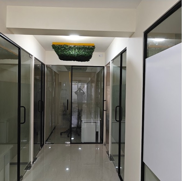 Hallway with glass-walled cabins at 43 Workspace